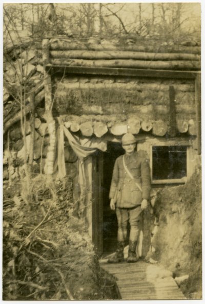 Soldier Standing in Doorway of Shelter Built Into the Side of a Small Hill by Carl Michel